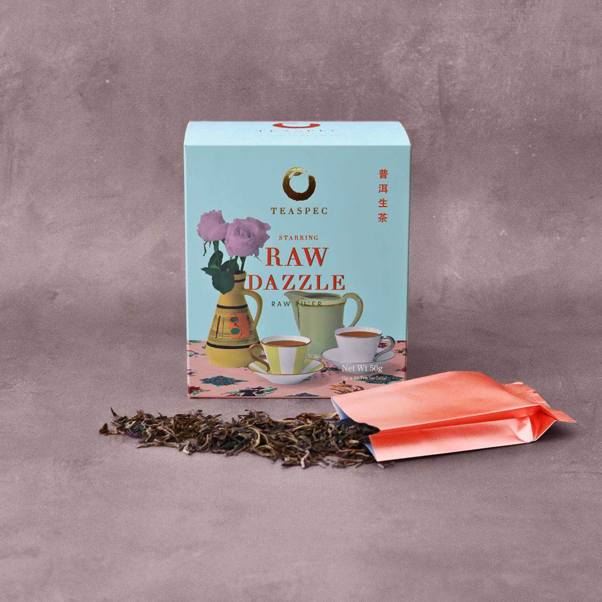 TEASPEC RAW DAZZLE Raw Pu'er Loose Leaf Chinese tea box with a tea sachet in front that has the loose-leaf tea leaves spread in front.