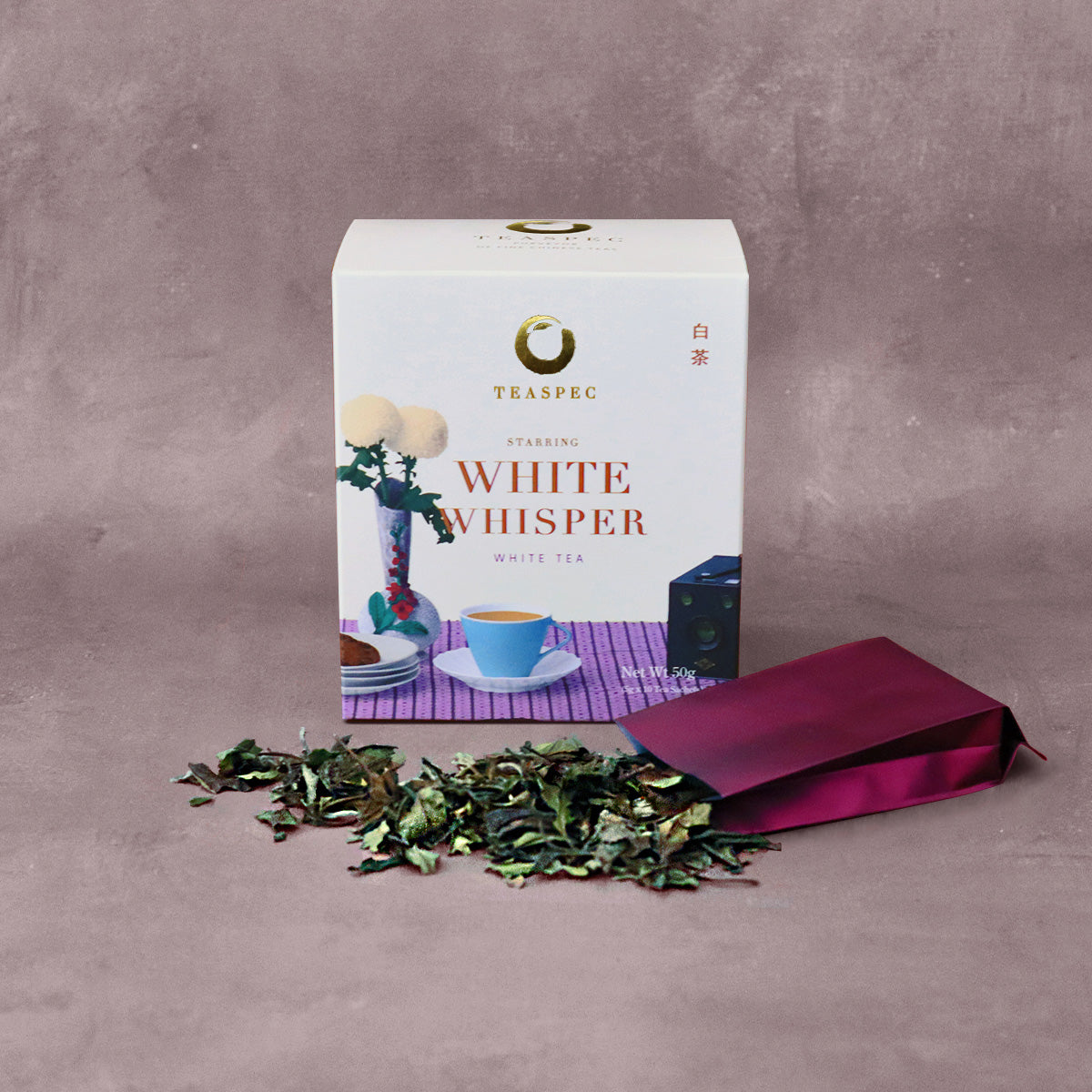 WHITE WHISPER White Tea Shou Mei Loose Leaf Chinese tea box with an open sachet with loose leaf tea leaves spread out in front.