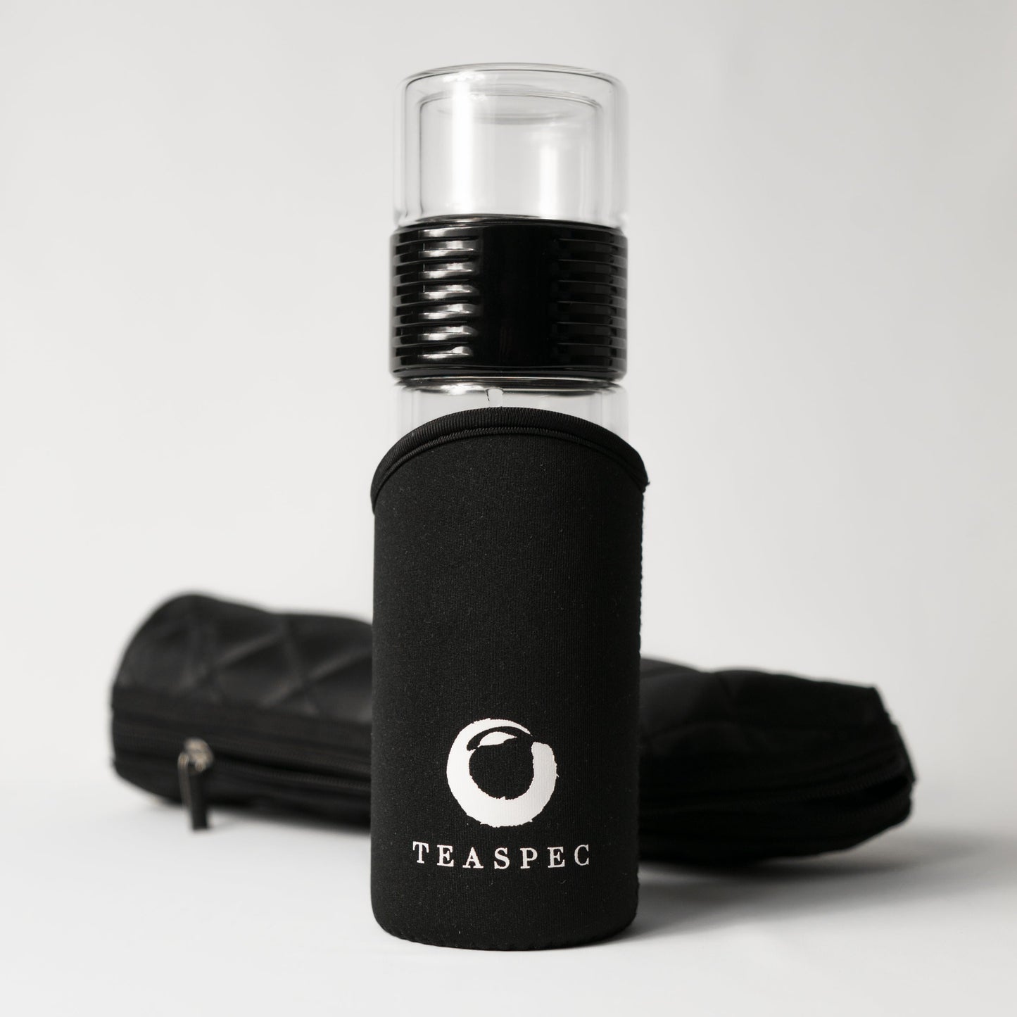 Black glass lazy go glass travel tumbler with black sleeve and TEASPEC logo on a white background