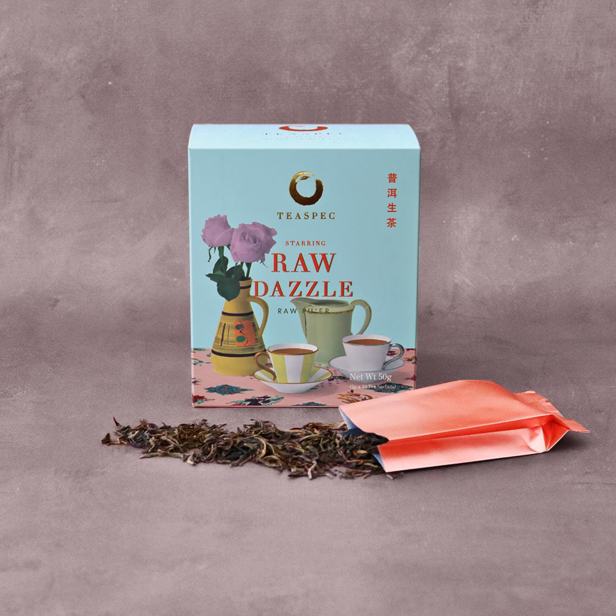 TEASPEC RAW DAZZLE Raw Pu'er Loose Leaf Chinese tea box with a tea sachet in front that has the loose-leaf tea leaves spread in front. 