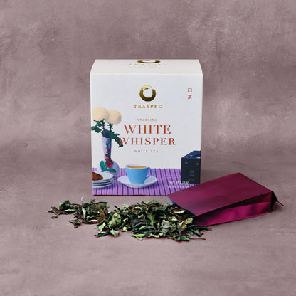 WHITE WHISPER White Tea Shou Mei Loose Leaf Chinese tea box with an open sachet with loose leaf tea leaves spread out in front.