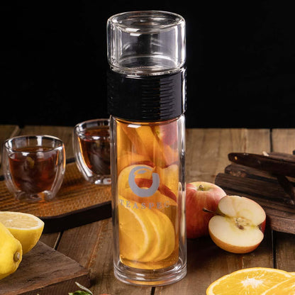 Lazy_Go_Glass_Tea_Travel_Tumbler_350ml on a wooden surface with 2 easy sip teacups and apples next to it. The tumbler is filled with orange and slices, apples and strawberries.